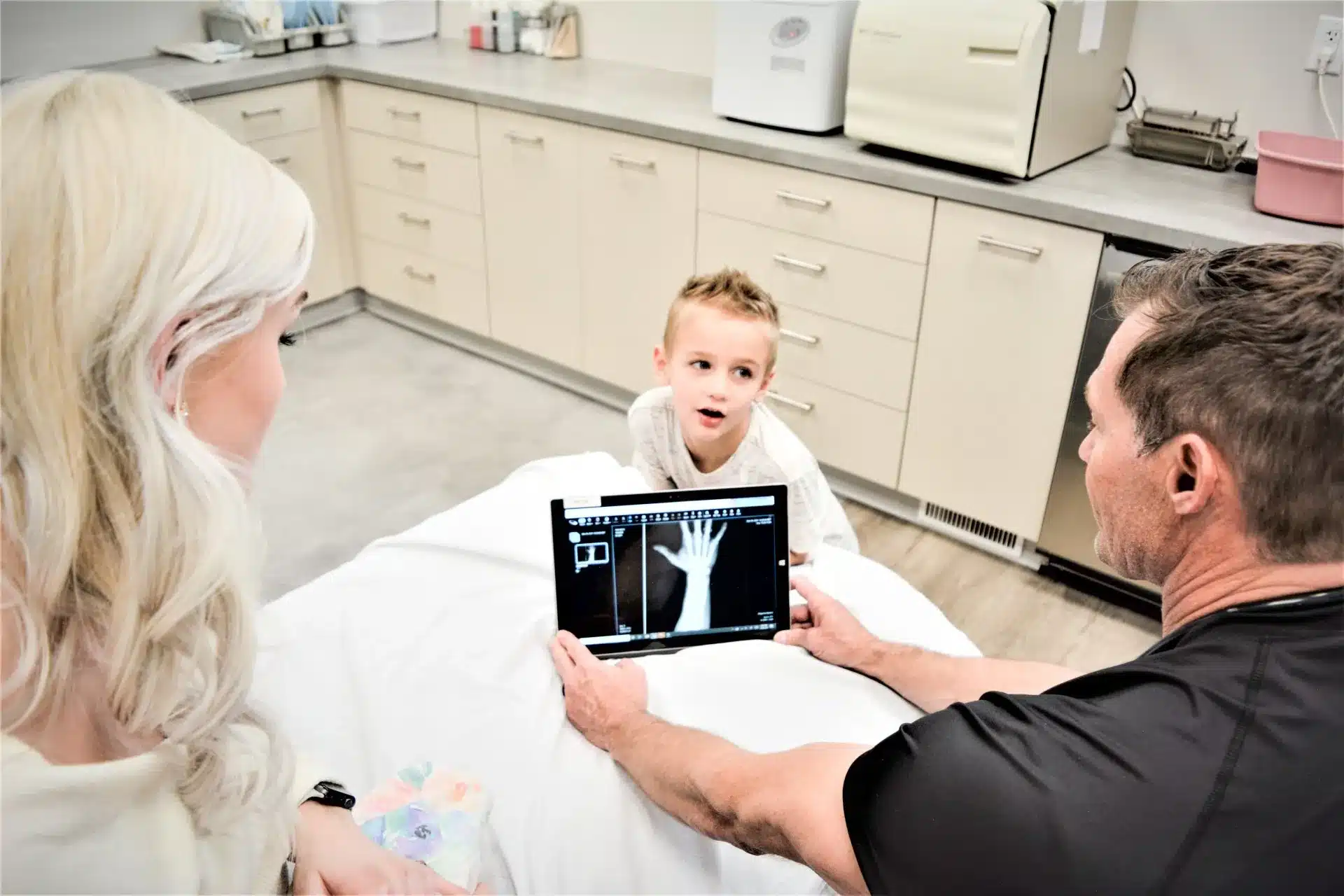 Dr. Danny Spencer showing x-rays to a mom and child at Ridgeline Medical in Idaho Falls, ID
