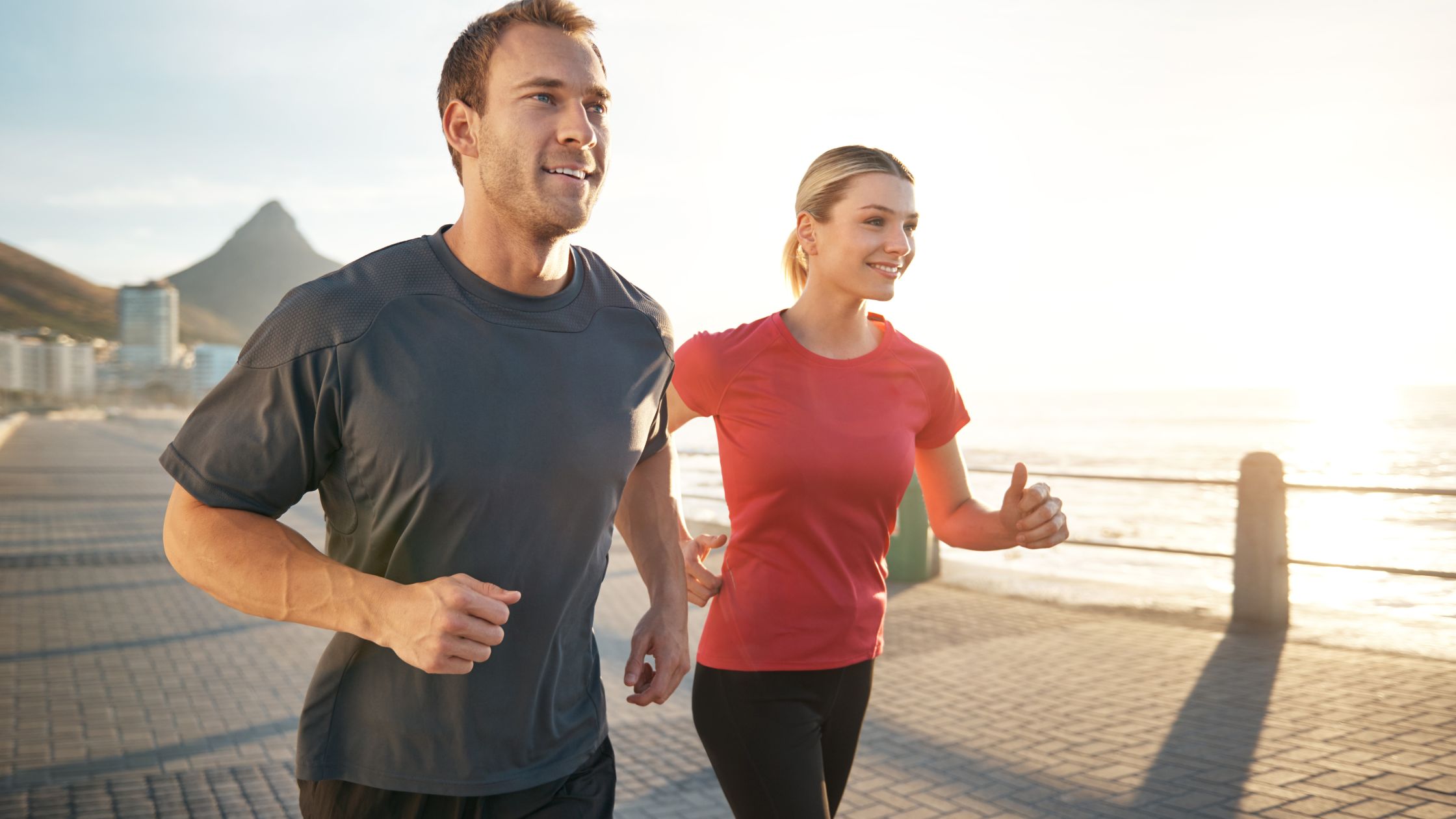 Man and woman jogging together along a scenic waterfront path, promoting an active lifestyle and weight loss success through personalized medical support at Ridgeline Medical.